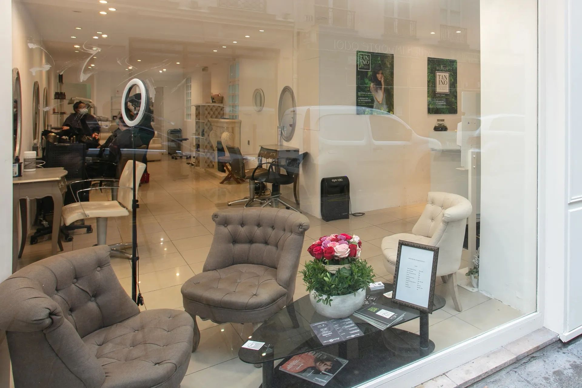 Le coin d’attente en vitrine : fauteuils capitonnés en velours taupe et bouquet de roses