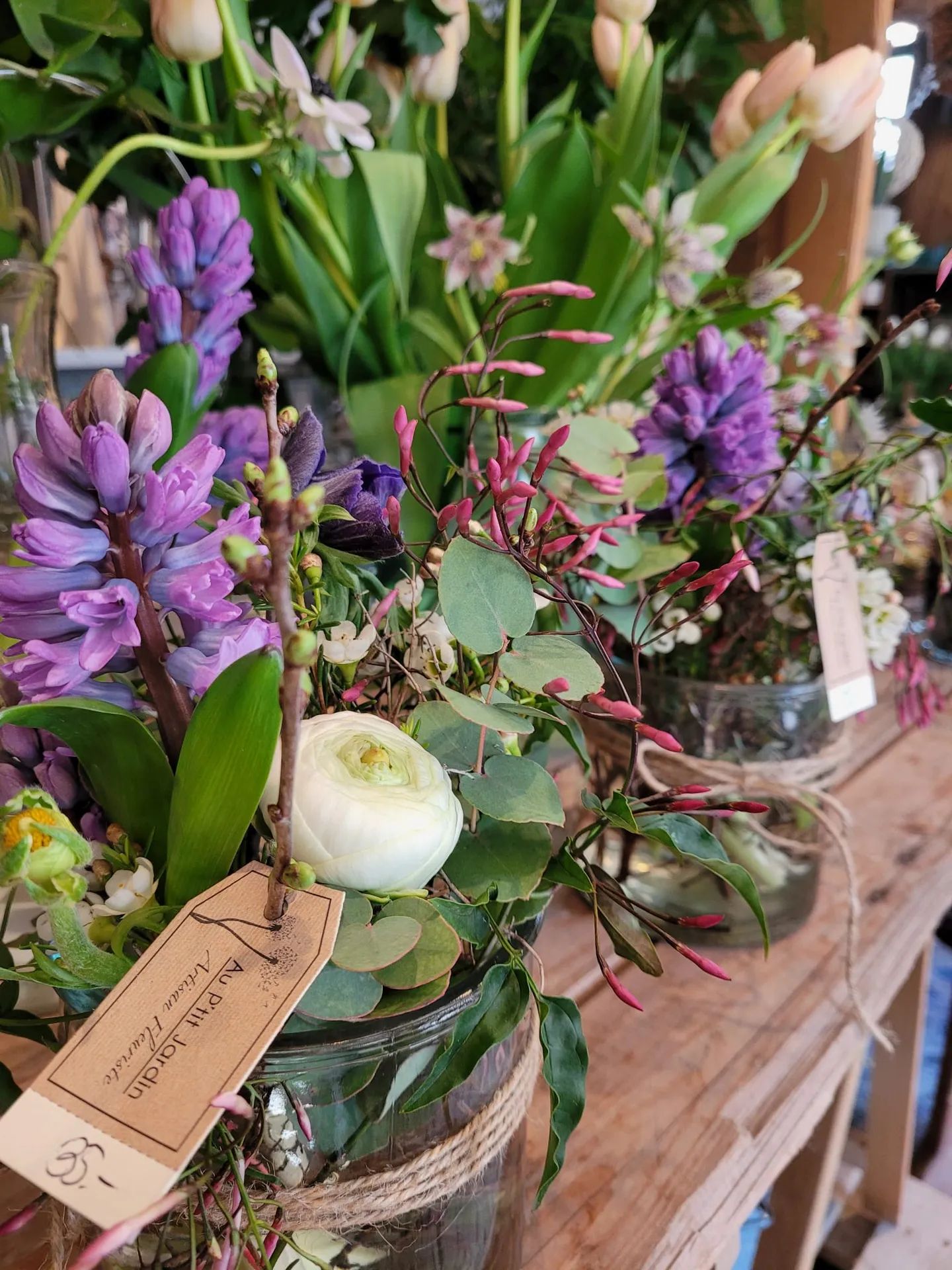 Bouquet de jacinthes violettes, tulipes et renoncule blanche, étiquette kraft de la boutique