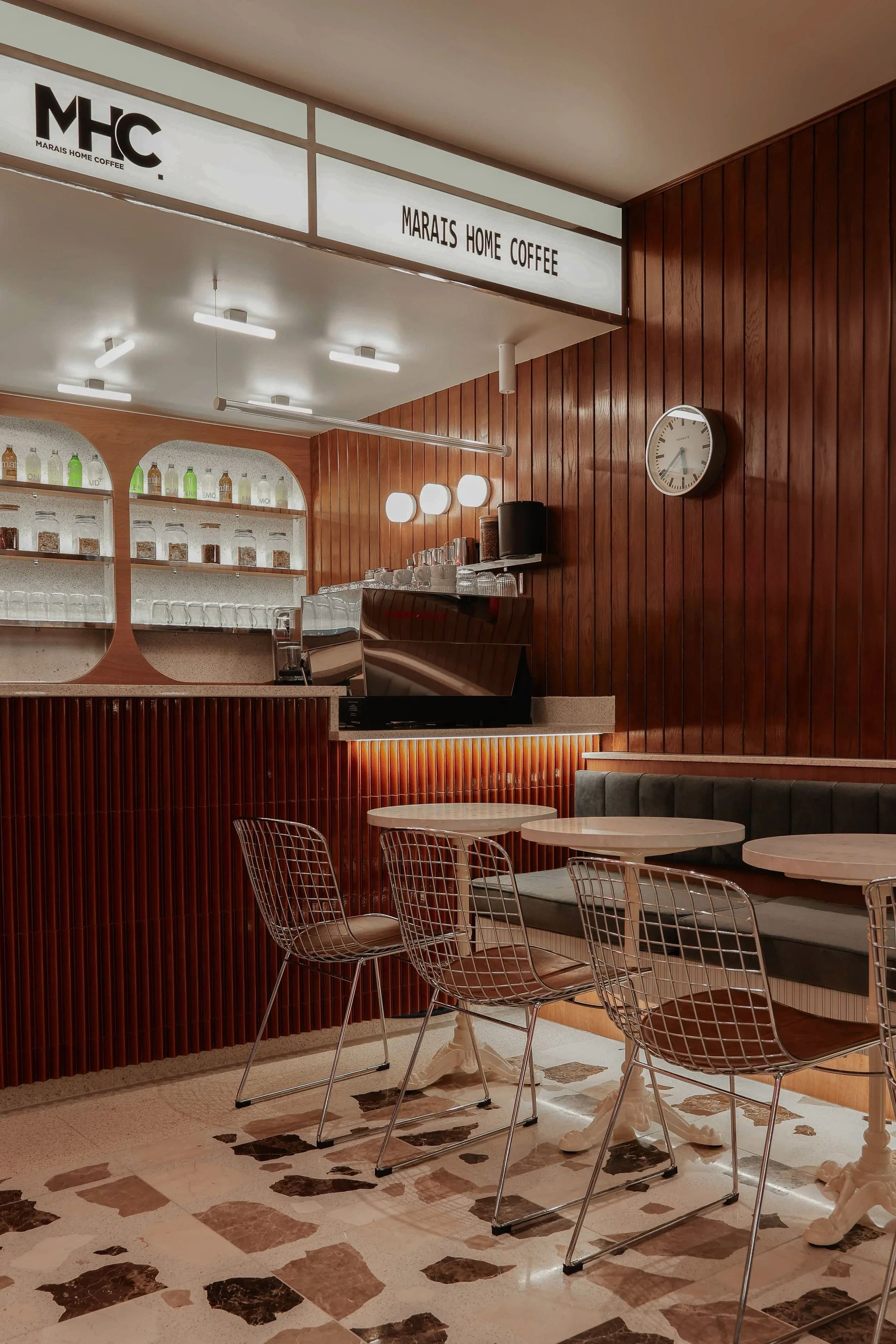 Le comptoir en lattes de noyer sous la marquise blanche MHC